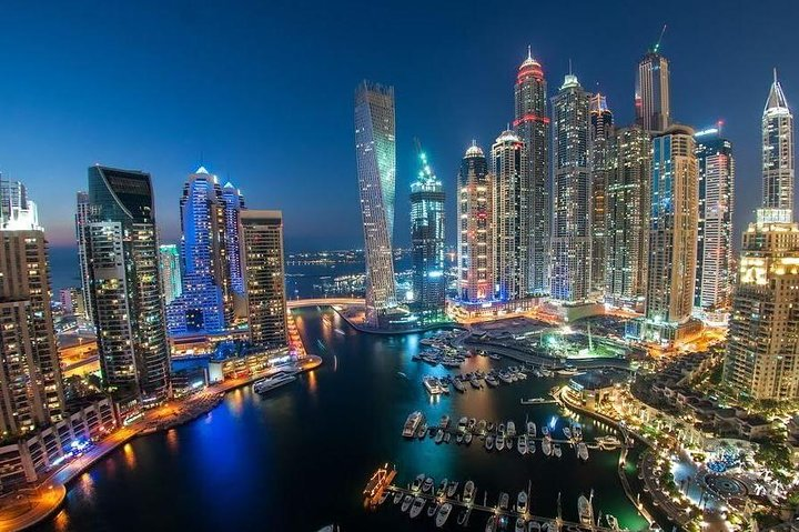 Explore Dubai’s skyline as it sparkles at night with iconic landmarks like the Burj Khalifa and Burj Al Arab shining bright offering travelers a unique view of urban elegance.